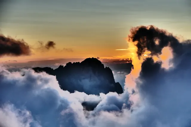 Cime delle Dolomiti che emergono dalle nuvole al tramonto